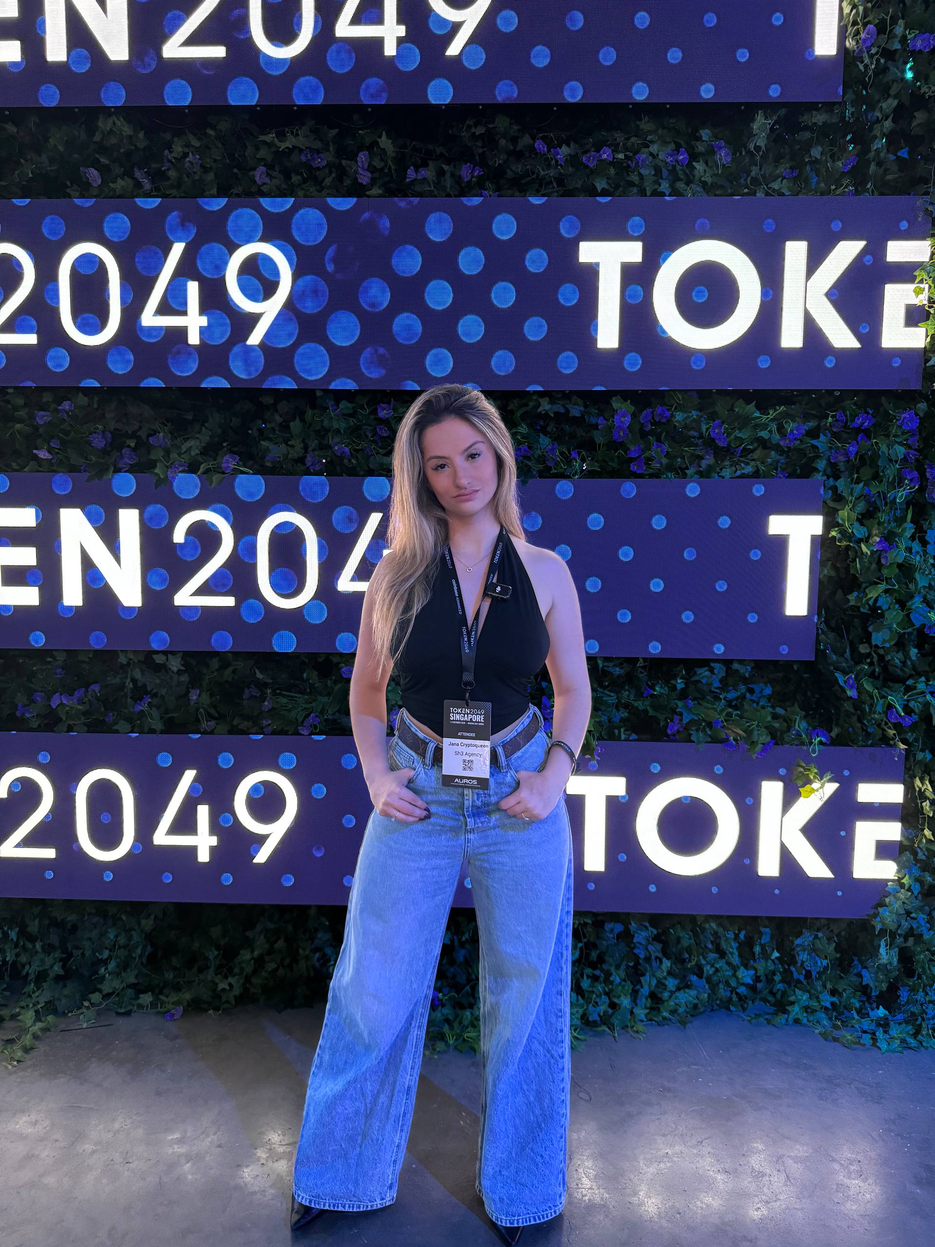 Jana at TOKEN2049 Singapore with purple backdrop